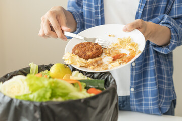 Compost from leftover food, refuse asian young housekeeper woman, girl hand using fork scraping waste from dish, throwing away putting into garbage, trash or bin..Environmentally responsible, ecology.