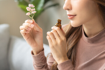 Aromatherapy, asian young woman, girl hand holding flower, bottle of essential perfume oil,...