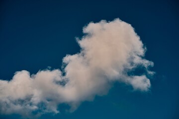 A piece of a blue sky with many clouds around. Midday cloudscape in the summer sky.