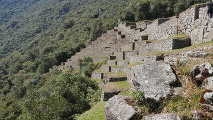 La ville de l'Inca Machu Picchu au sommet d'une montagne, avec les hautes montagnes voisines, son environnement vertigineux, ses murs de pierre bien polis, son jardin naturel et sa construction  - obrazy, fototapety, plakaty