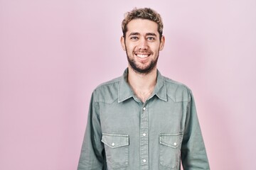Obraz premium Hispanic man with beard standing over pink background with a happy and cool smile on face. lucky person.