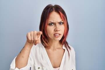 Obraz premium Young caucasian woman wearing casual white shirt over isolated background pointing displeased and frustrated to the camera, angry and furious with you