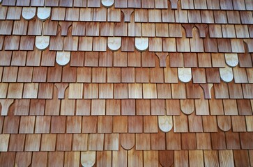 Rot-braun-weiße Holzfassade von Haus mit gestreiftem Kästchenmuster 