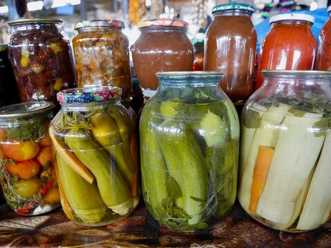 Jars with homemade pickled vegetables on sale at local farmers market.