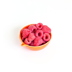 Small bowl of fresh organic raspberries isolated on white background. Cooking ingredient.