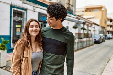 Fototapeta premium Young interracial couple smiling happy and hugging standing at the city.
