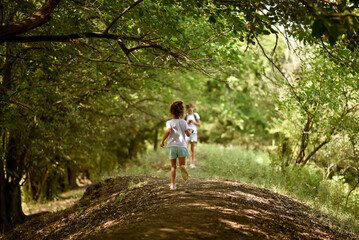 Fototapeta na wymiar A girl in a white T-shirt runs under the trees. Nature. Backgroung. Beautiful.