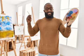 Young african american artist man smiling happy drawing at art studio.