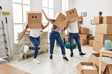 Mother and couple playing with funny cardboard box on head at home