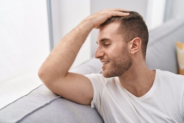 Young caucasian man smiling confident sitting on sofa at home