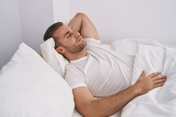 Fototapeta na wymiar Young caucasian man lying on bed sleeping at bedroom