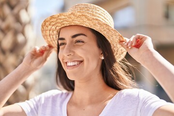 Young hispanic woman tourist smiling confident standing at street