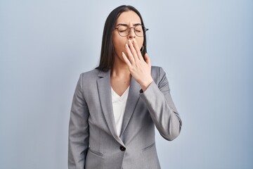 Hispanic business woman wearing glasses bored yawning tired covering mouth with hand. restless and sleepiness.