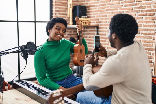 African American Man And Woman Music Group Make Photo Holding Ukelele At Music Studio