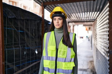 Young beautiful hispanic woman architect standing with serious expression at street