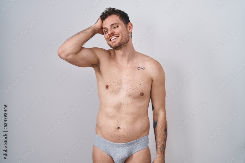 Canvas Prints Young hispanic man standing shirtless wearing underware smiling confident touching hair with hand up gesture, posing attractive and fashionable