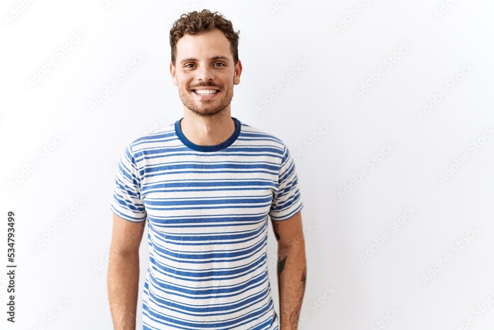 Poster handsome young man standing over isolated background with a happy and cool smile on face. lucky pers