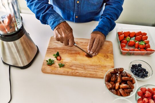 Senior man cutting datil at kitchen