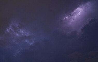Fulmini e tuoni durante una tempesta nel cielo nuvoloso viola.