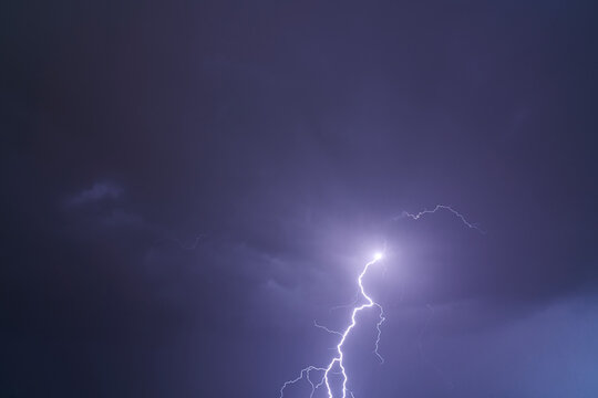 Fulmini e tuoni durante una tempesta nel cielo nuvoloso viola.