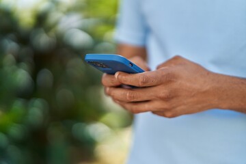 African american man using smartphone at park