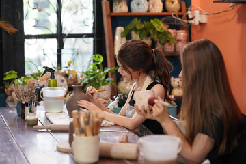 portrait of young woman shaping clay while making ceramics in pottery workshop, small business concept, copy space