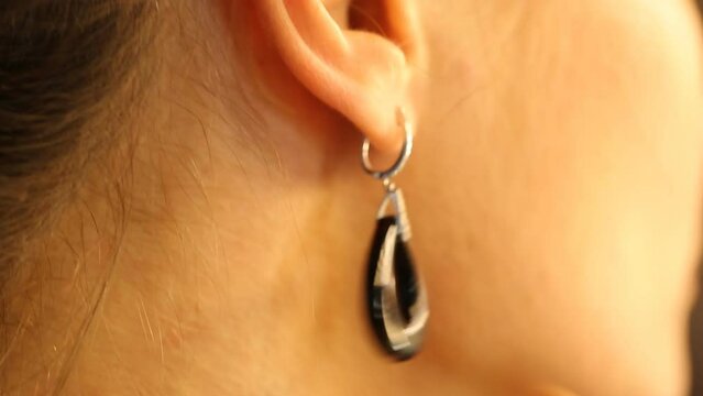 Woman putting earring