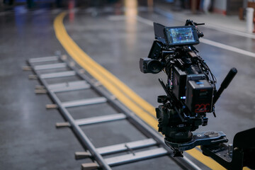 A professional film and video camera on the set. Filming day, equipment and crew. Technique of modern video filming.