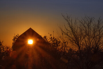 the sun through the window of the house opposite