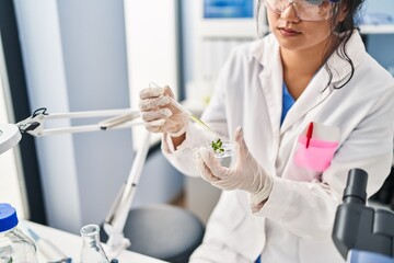 Young chinese woman wearing scientist uniform working at laboratory