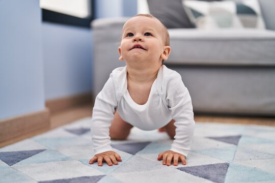 Adorable toddler crowling on floor at home