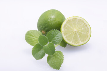 Green limes, cut in half and whole, fresh mint isolated on a white background.