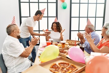 Group of middle age friends smiling happy celebrate birthday at home.