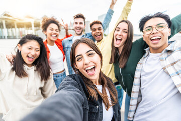 Obraz na płótnie Canvas Multiracial friends taking selfie group picture with smart mobile phone outside on city street - Happy young people smiling together looking at camera - Youth lifestyle concept with teens hanging out