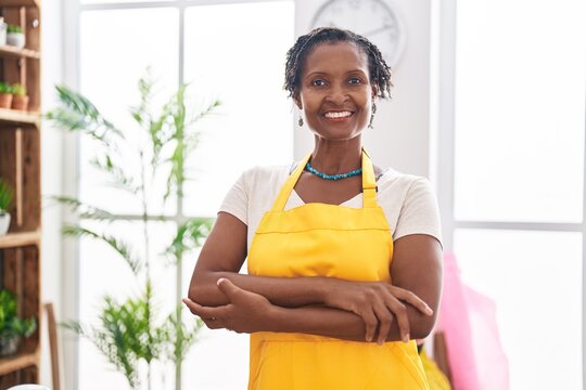 Middle age african american woman florist smiling confident standing with arms crossed gesture at flower shop