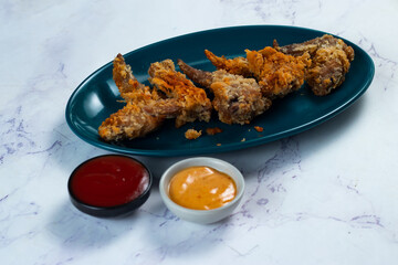 Crispy chicken wings with tomato sauce and mayo dip isolated on cutting board side view of fastfood