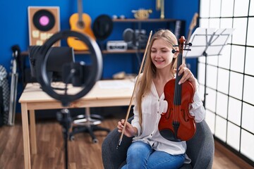 Fototapeta na wymiar Young caucasian woman musician having online violin lesson at music studio