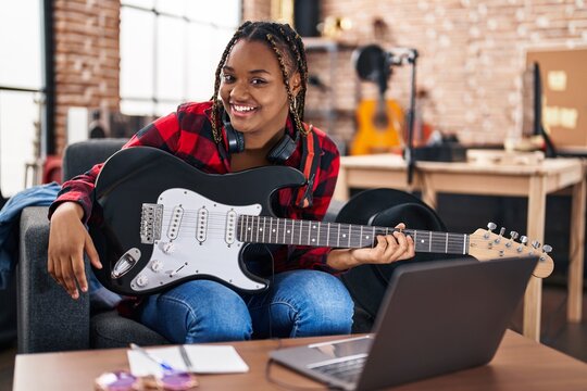 African american woman musician having online electrical guitar lesson at music studio