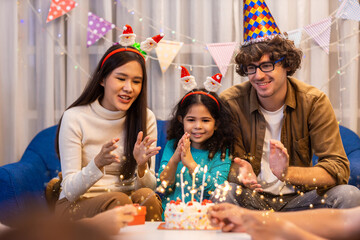 Celebrating Little girl birthday, blowing candles on homemade baked cake, indoor. Birthday party for Little girl	
