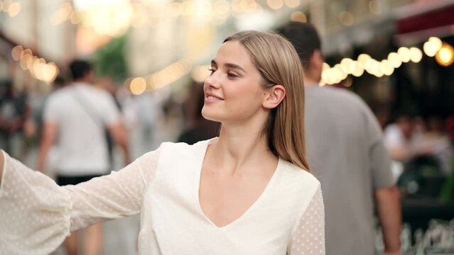 Beautiful Happy Young Blonde Woman Making a Video call Smiling Talking Walking Relaxed on the City Background