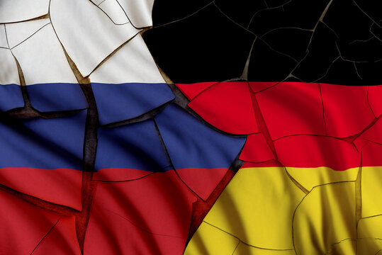 Russia vs German gas and oil conflict, economic concept : Russian and German flags on a cracked wall, depicting the impact of Russia's invasion of Ukraine on Europe and the global energy market.
