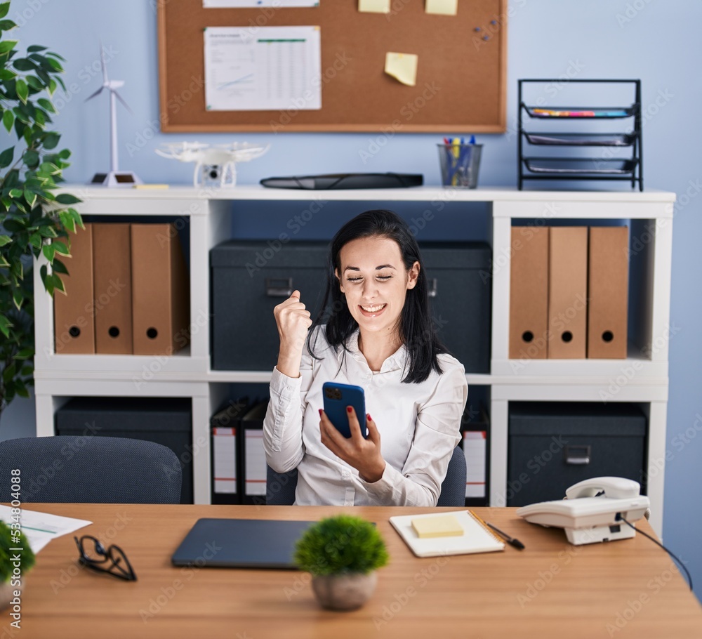 Canvas Prints Young caucasian woman business worker using smartphone with winner expression at office