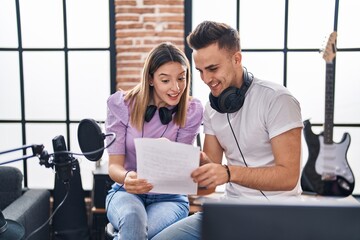Man and woman musicians singing song at music studio