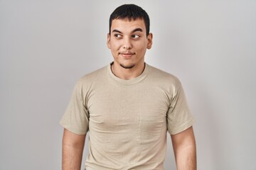 Obraz premium Young arab man wearing casual t shirt smiling looking to the side and staring away thinking.