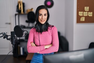 Young caucasian woman musician smiling confident standing with arms crossed gesture at music studio