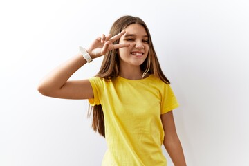 Young brunette teenager standing together over isolated background doing peace symbol with fingers...