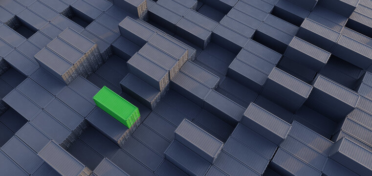 A single green shipping containing on top of a large stack of grey shipping containers