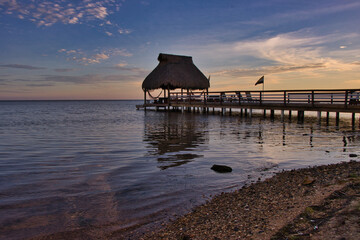 caribbean sunset with bungalow and jetty