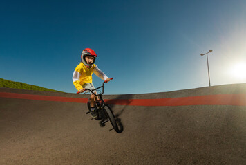 A Teenager BMX Racing Rider Performs Tricks on a Pump Track.