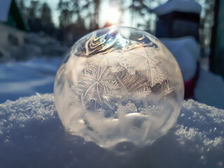 Macro of round, frozen soap bubble forming beautiful leaf and tree like pattern while freezing in...